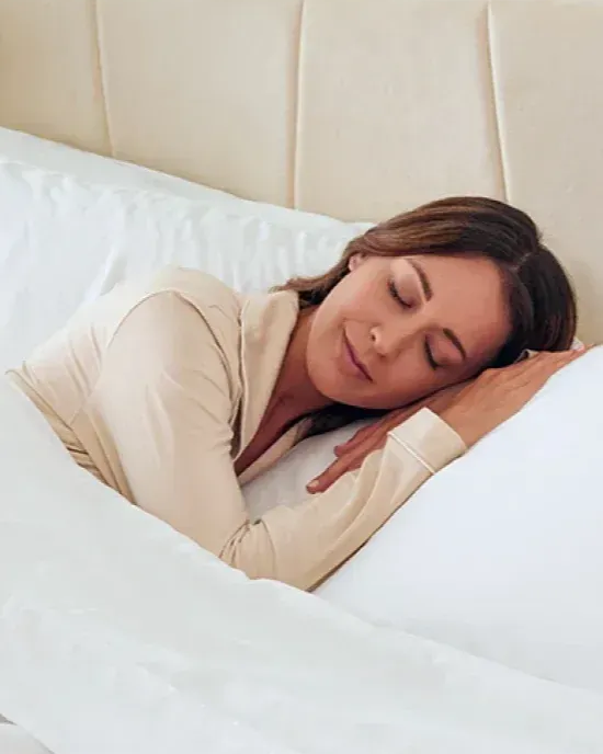 Woman sleeping comfortably on soft white Miracle Sheets bedding